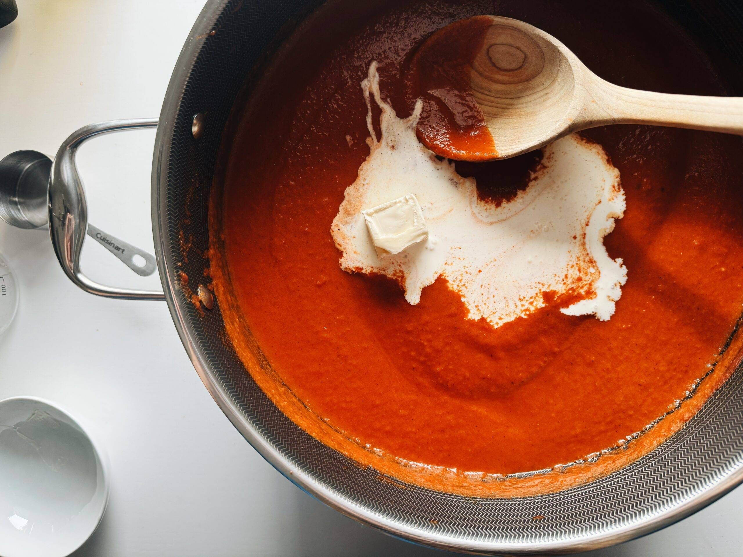 Adding butter and cream to sauce.