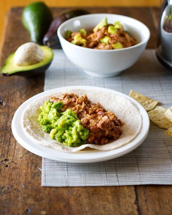 Mexican chicken and pinto beans on a tortilla.