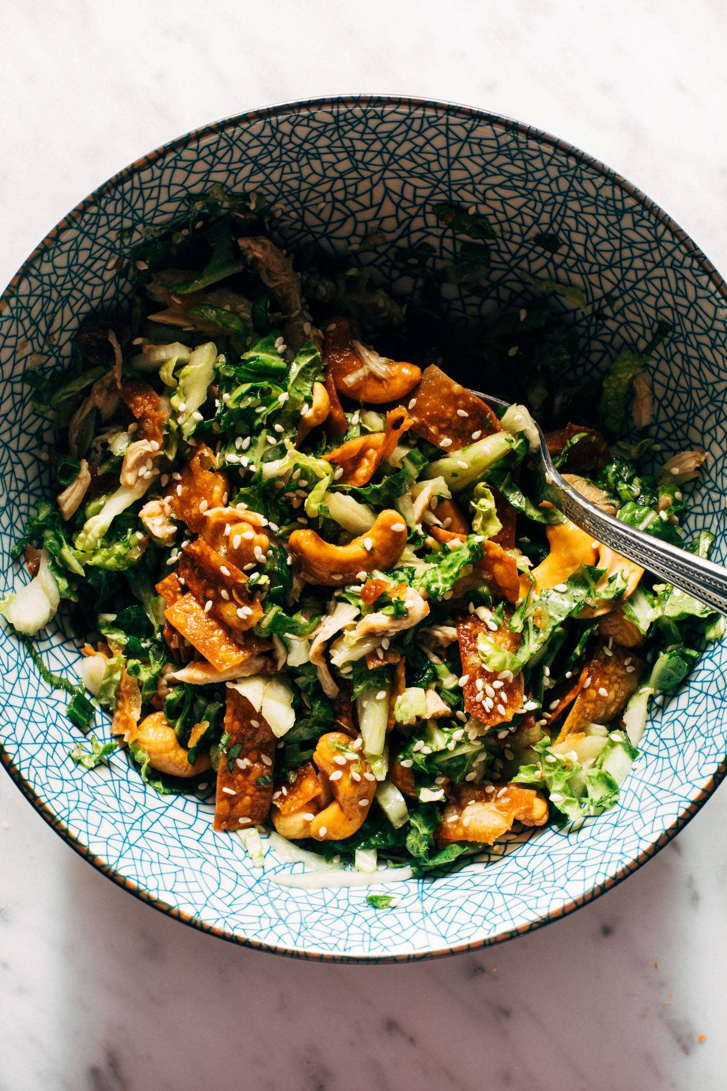 Chicken salad in a bowl with cashews and wonton strips.