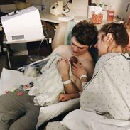 Bjork holding Afton with Lindsay sitting next to him.