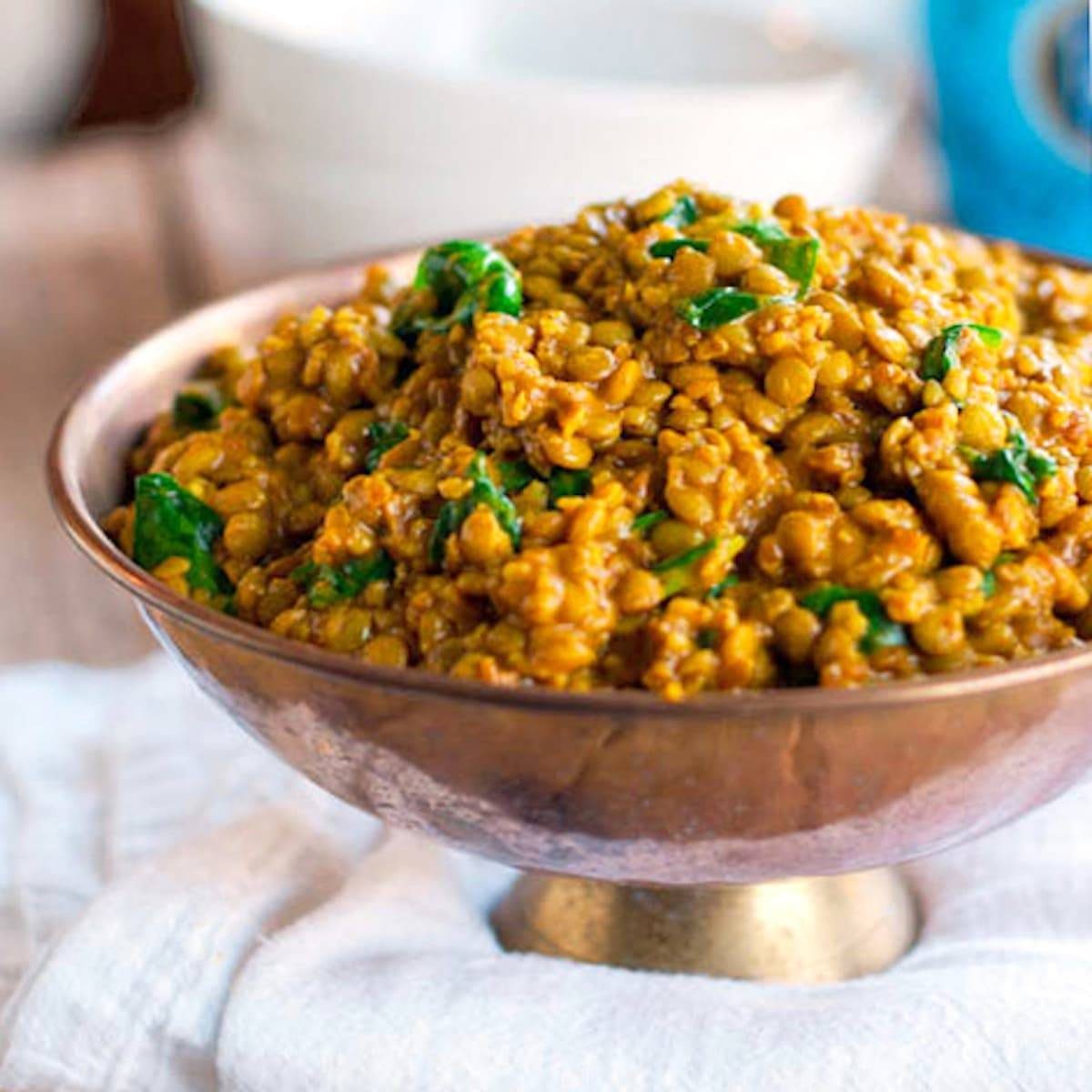 Coconut green curry lentils in a copper bowl.
